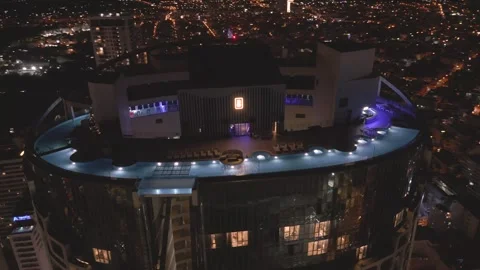 City skyline view from rooftop infinity pool night showcasing vibrant lights Video stock 297928578