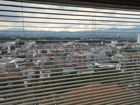 City Skyline View Through Window Blinds with Mountains in Distance Stock Photos