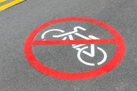 City street asphalt road with bicycle riding not allowed symbol sign mark with Stock Photos