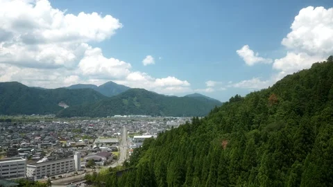 The city is surrounded by mountain with Green pine trees Stock Footage 259886462