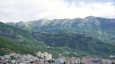 The city is surrounded by mountains with passing clouds over it. Timelapse Stock Footage 111907677
