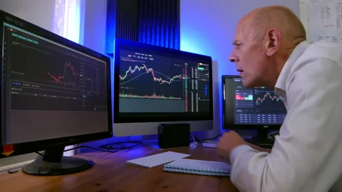 A city trader in a crypto and forex stock trading office. The mature man Stock Footage 166018962