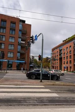 City traffic passes between brick apartment blocks and signal lights at wid.. 库存照片
