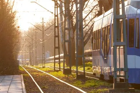 City trams in the rays of the sunset soft bright back-light sun, glare on the Stock Photos