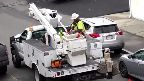 City utility worker prepares cable before ascending to telephone pole Video stock 236859869