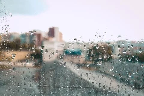 City view through the wet window on a rainy day. Stay home in daylight Stock Photos