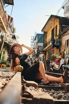 This city will electrify all of your senses. a woman having coconut water while Stock Photos