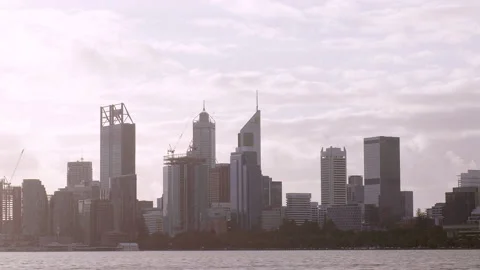 City winter scene of clouds rolling overhead, river and flashes of bike riders. Video stock 196140281