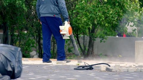 City worker cleans public sidewalks with vacuum cleaner Stock Footage 246472471