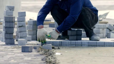 City worker compacts paving slabs with rubber hammer Stock Footage 243299580