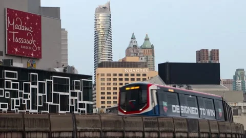A cityscape featuring a metro train passing in front of unique building Stock Footage 341087146