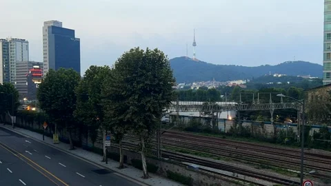 Cityscape with a moving train on parallel tracks, modern buildings and streets Stock Footage 302073641