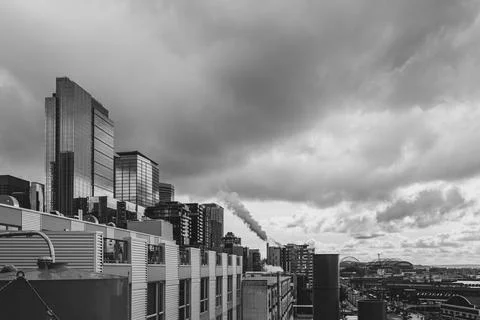 Cityscape of Seattle with dark clouds and dark vapor rising from smoke stack Stock Photos