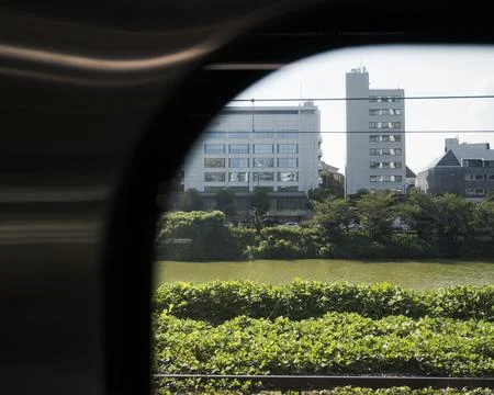 Cityscape seen through train window near river Stock Photos