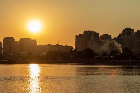 A cityscape shoot with low shutter speed - orange sun is shining inside cloud Stock Photos