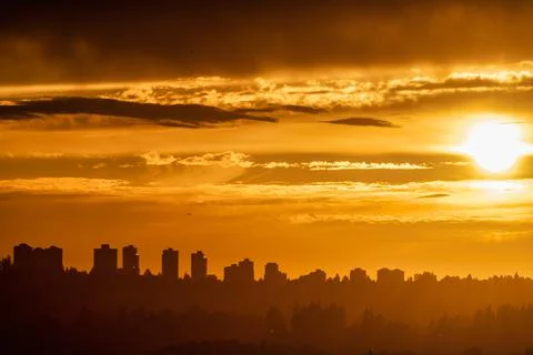Cityscape on sunset cloudy sky background closer to the night Stock Photos