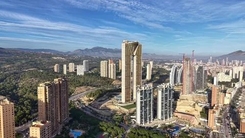 Cityscape With Towering Structures And Distant Mountains, Highrise Building Stock Photos