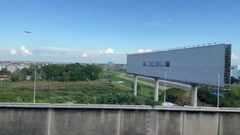 Cityscape view on moving train, empty billboard, blue sky, vehicles moving Stock Footage 183538746