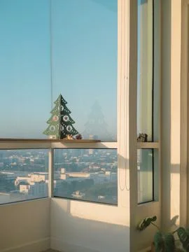 Cityscape viewed through window with plants under clear blue sky Stock Photos