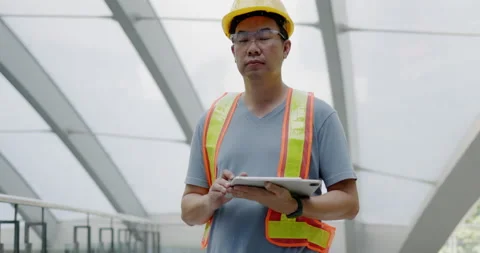 Civil construction engineer is standing and using tablet to check construction Stock Footage 166566358