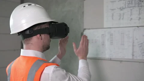 A civil engineer analyzes the work of builders using virtual reality glasses Video stock 182373265