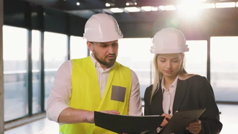 A civil engineer and an architect manager are discussing the plan for the Stock Footage 236691164