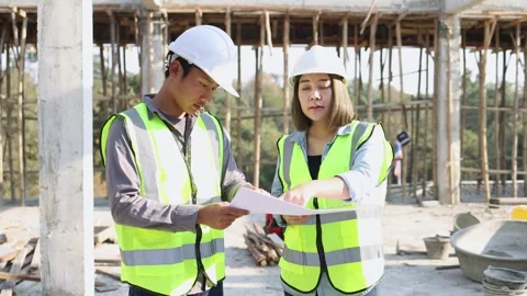 Civil engineer and construction worker manager holding digital tablet and b.. Stock Footage 336935318