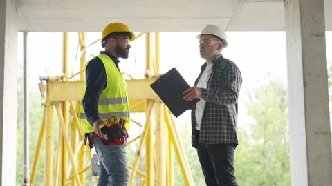 Civil engineer and construction worker discussing project on site Stock Footage 343450590