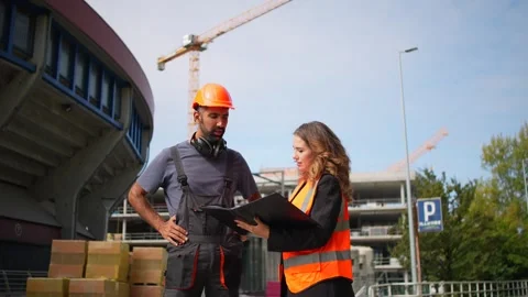 Civil engineer and construction worker discussing project plans on site Stock Footage 348274626