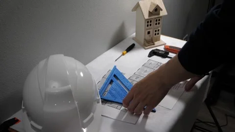 Civil engineer architech writing reading blueprints and looking at scale model Stock Footage 258423064
