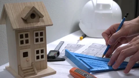 Civil engineer architech writing reading blueprints and looking at scale model Stock Footage 258423103