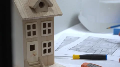 Civil engineer architech writing reading blueprints and looking at scale model Stock Footage 258423158
