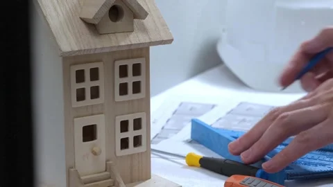 Civil engineer architech writing reading blueprints and looking at scale model Stock Footage 258423159