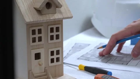 Civil engineer architech writing reading blueprints and looking at scale model Stock-Footage 258423207