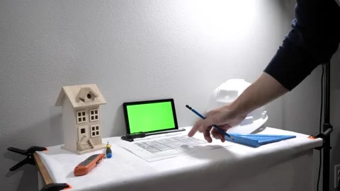 Civil engineer architech writing reading blueprints and looking at scale model Stock Footage 258423250