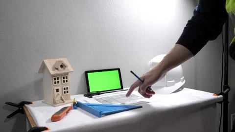 Civil engineer architech writing reading blueprints and looking at scale model Vidéo 258423316