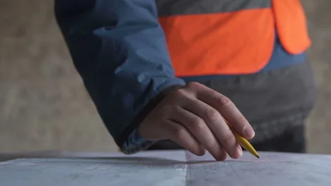 Civil engineer checks drawings at the construction site of a high-rise building 库存影片 129481931