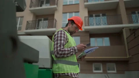 Civil engineer on construction site holding blueprints and smartphone in front Video stock 231252183