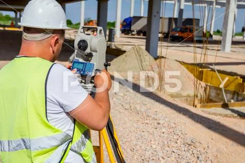 Civil engineer, geodesist is working with total station on a building site Stock Photos