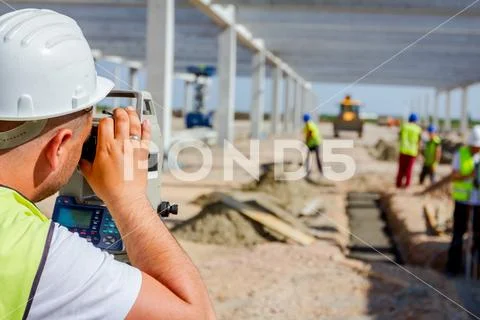 Civil engineer, geodesist is working with total station on a building site Stock Photos