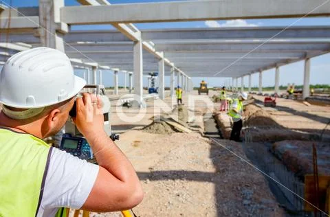 Civil engineer, geodesist is working with total station on a building site Stock Photos