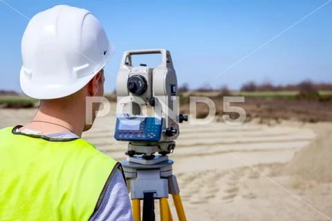Civil engineer, geodesist is working with total station on a building site Stock Photos