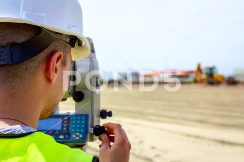 Civil engineer, geodesist is working with total station on a building site Stock Photos