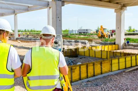 Civil engineer, geodesist is working with total station on a building site Stock Photos