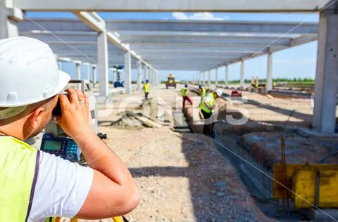 Civil engineer, geodesist is working with total station on a building site Stock Photos