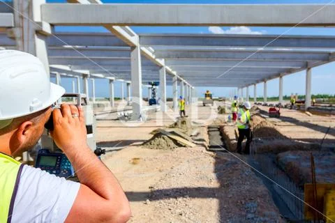 Civil engineer, geodesist is working with total station on a building site Stock Photos