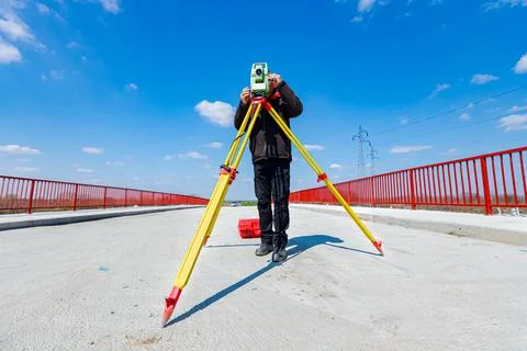 Civil engineer, geodesist is working with total station on a building site Stock Photos