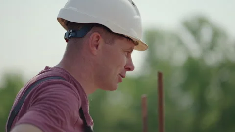 A civil engineer in a helmet is satisfied with the progress of the construction Stock Footage 263962341