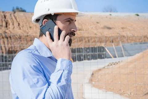 Civil engineer inspecting work, call to supervisor with smartphone standing Stock Photos
