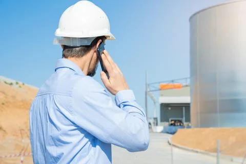 Civil engineer inspecting work, call to supervisor with smartphone standing Stock Photos